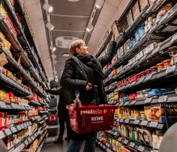 Eine Frau nutzt den REWE-Einkaufs-Bus, um ihre Einkäufe zu machen. (Foto: REWE)